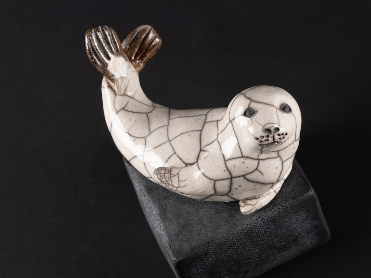 Phoque modelé en grès, émaillé, cuisson raku. Socle en grès enfumé.