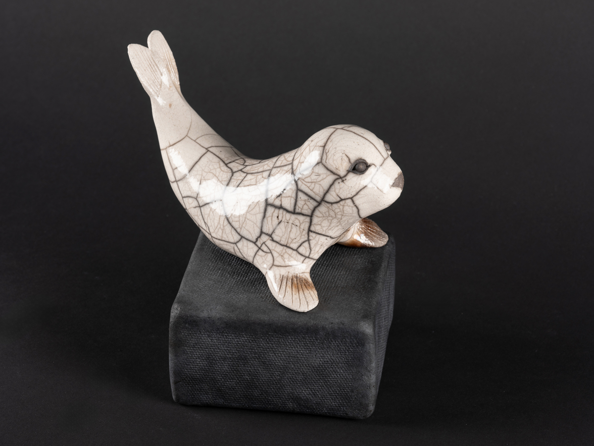 Phoque modelé en grès, émaillé, cuisson raku. Socle en grès enfumé.
